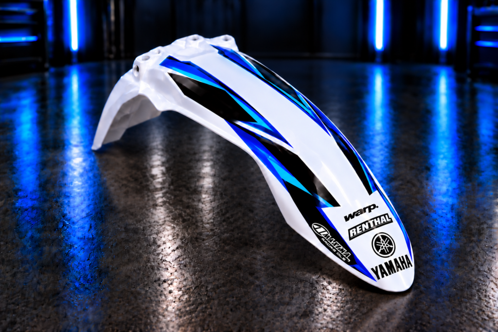 Custom blue, cyan and black front fender decals with example Yamaha, Renthal, WARP and Maxima logos; plastic fender not included